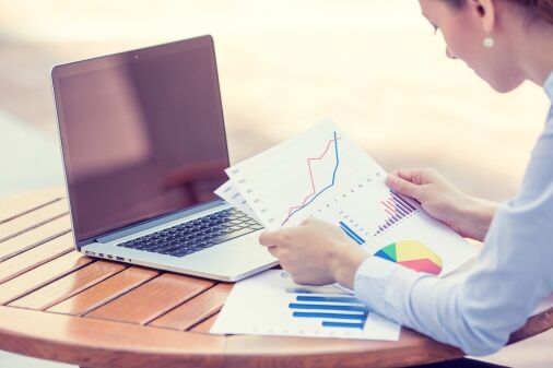woman investment consultant analyzing company annual financial report balance sheet statement working with documents graphs. stock market office tax education concept. hands with ch