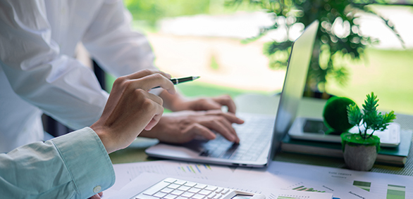 Two people working on a laptop together.