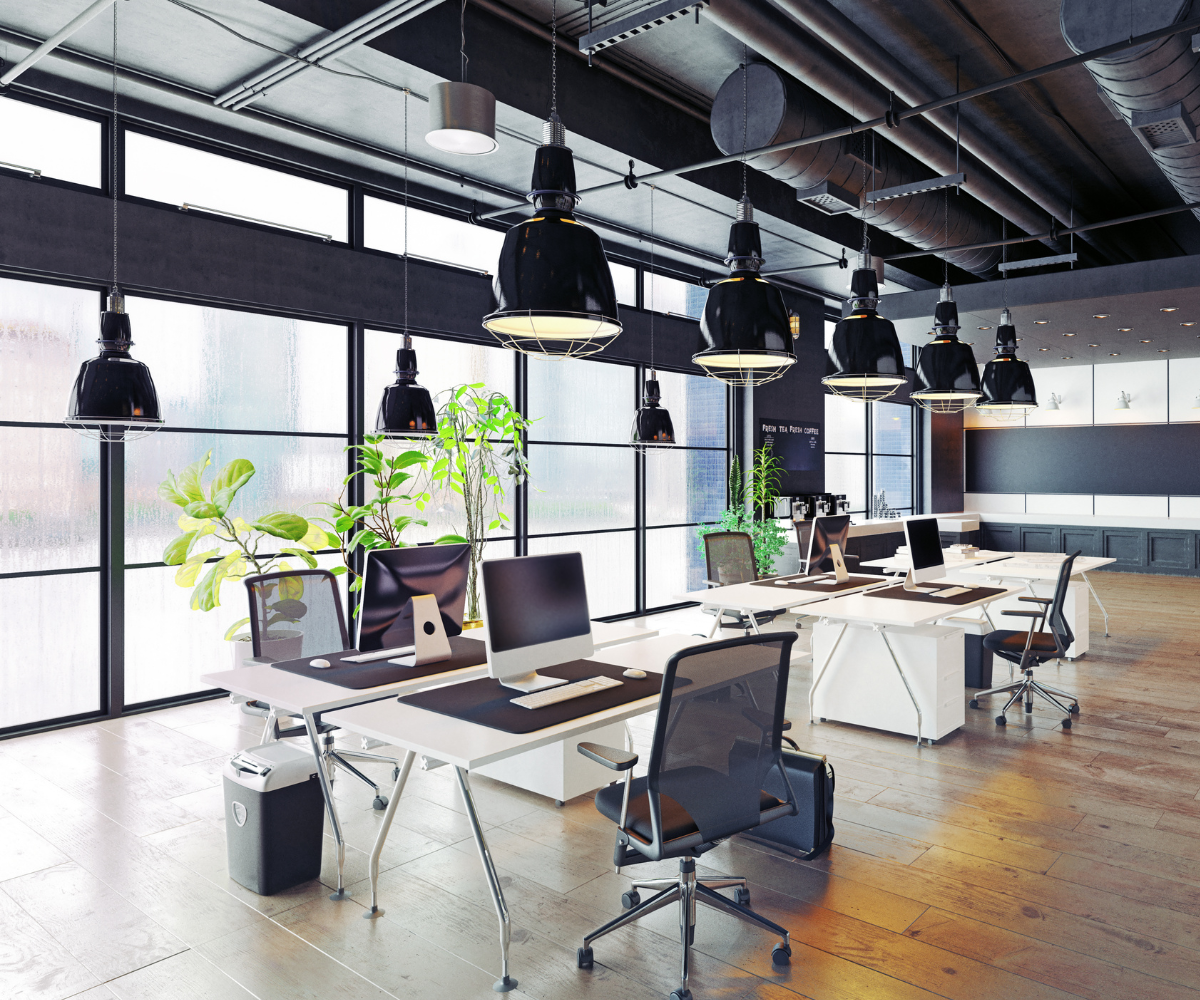 Modern office with desks, computers, and lighting.