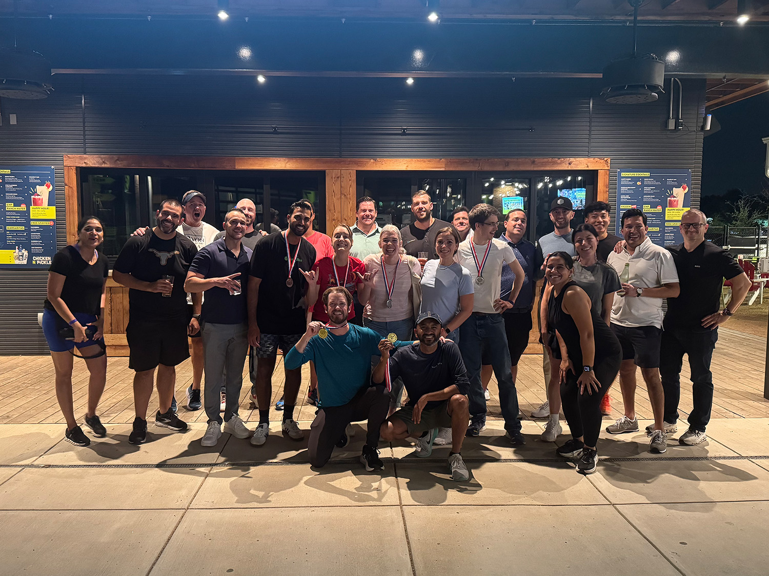 Group of people posing outside a venue.