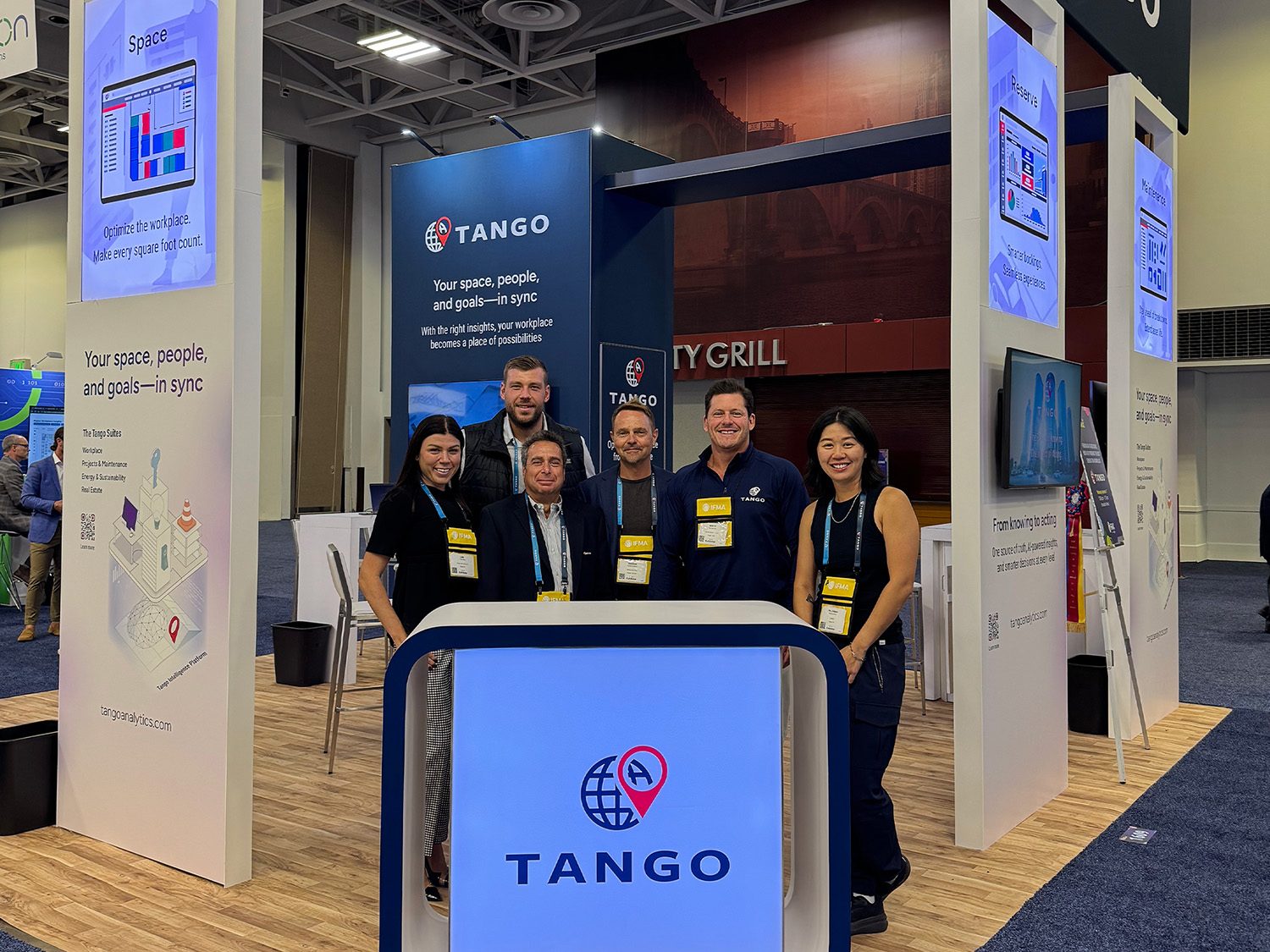 Tango exhibition booth with staff at a conference.