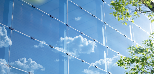 Reflective glass building with sky and clouds