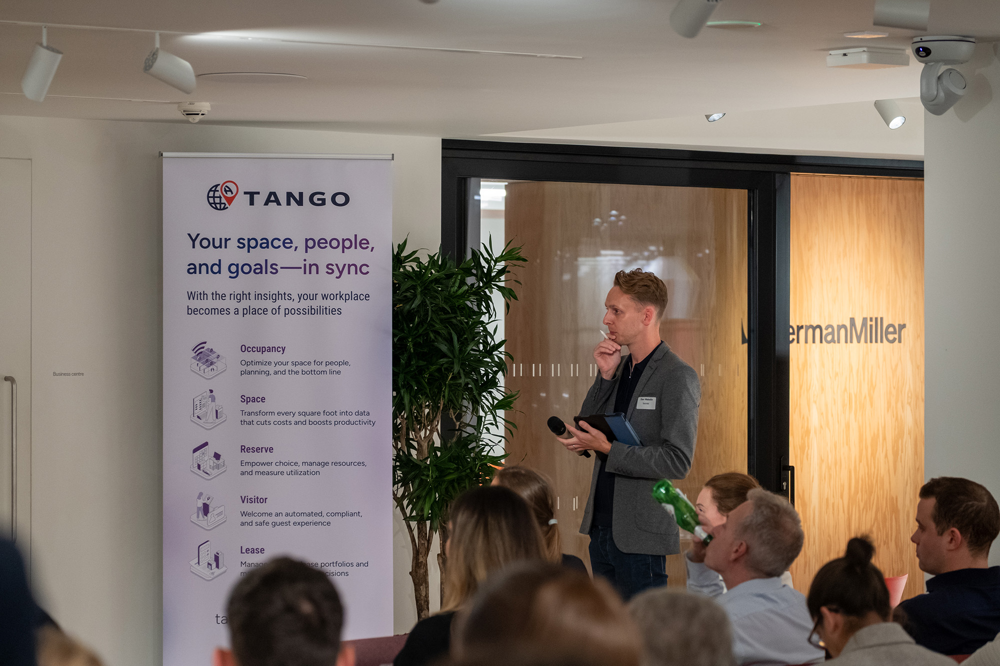 Man presenting at workplace optimization seminar.