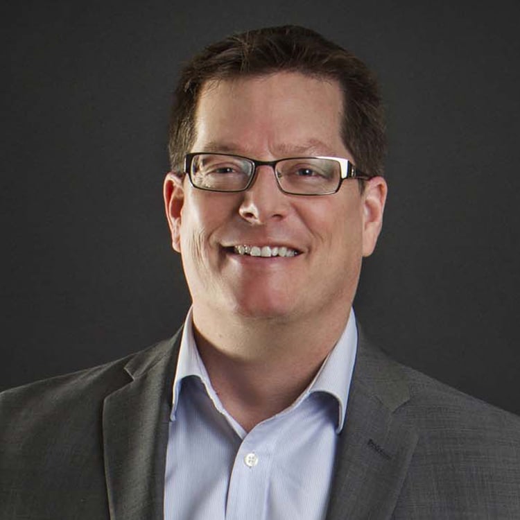 Smiling man with glasses and suit jacket