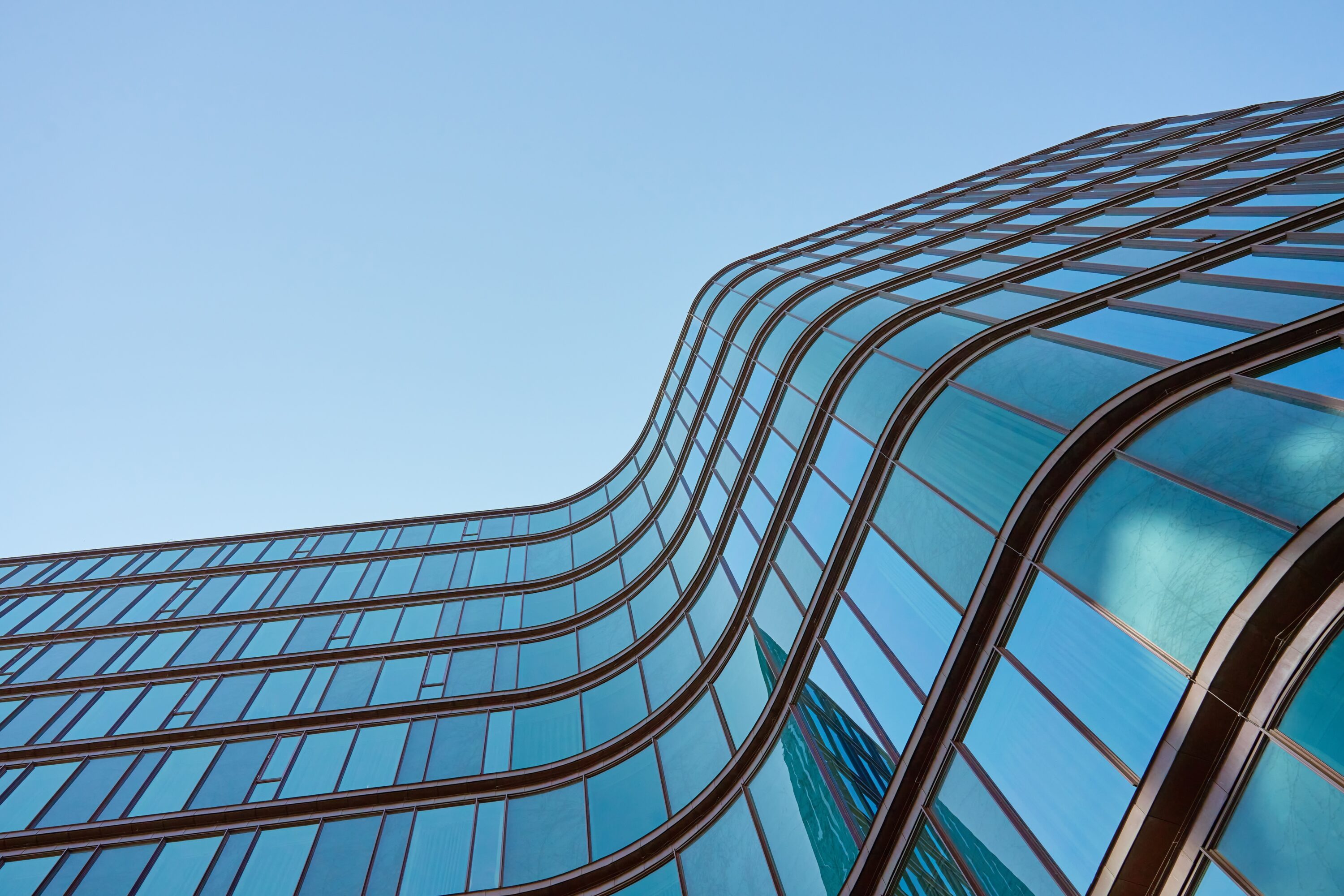 modern,building,with,curved,glass,facade,reflecting,sky.,contemporary,architectural