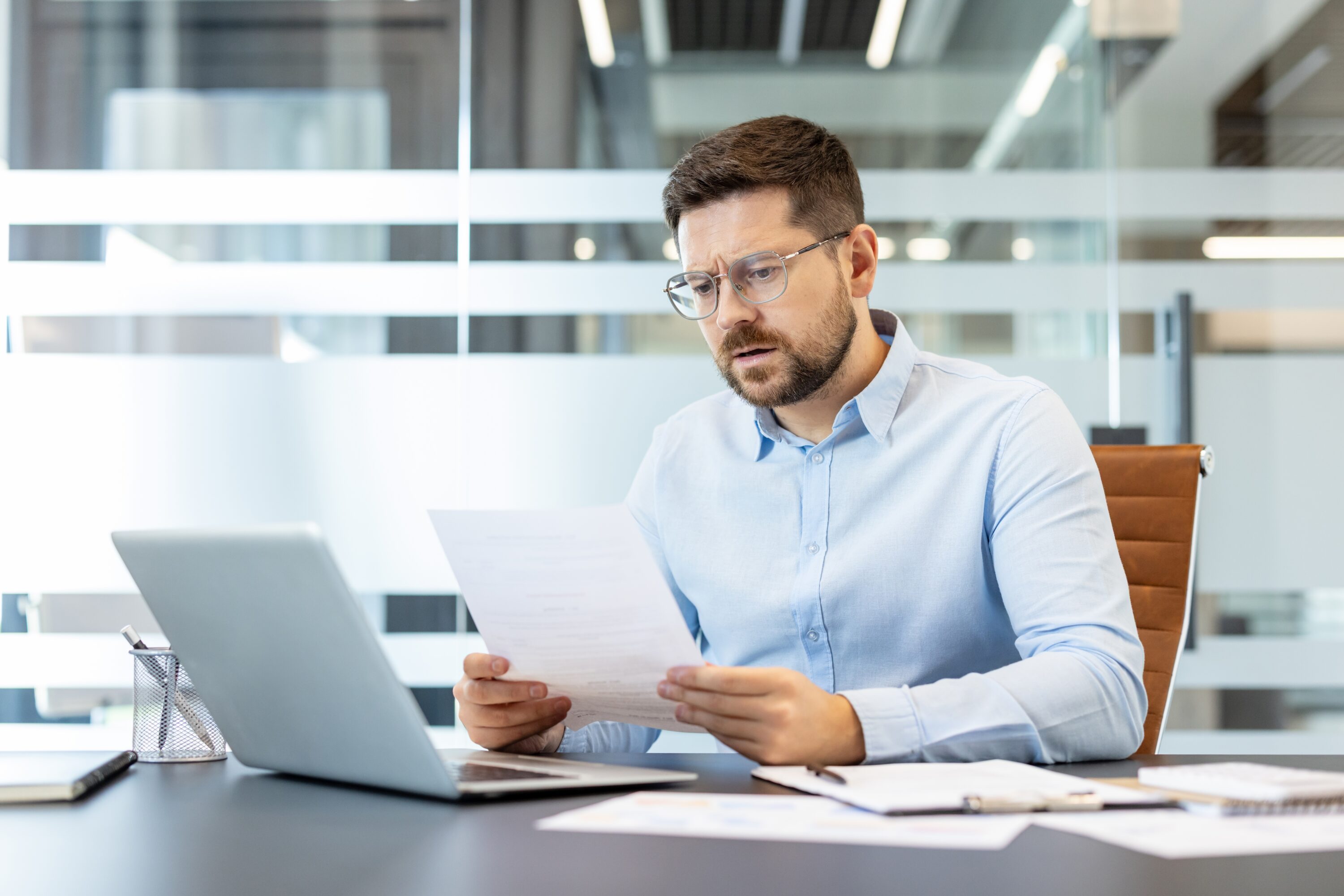 businessman,wearing,glasses,and,a,light,blue,shirt,concentrating,on