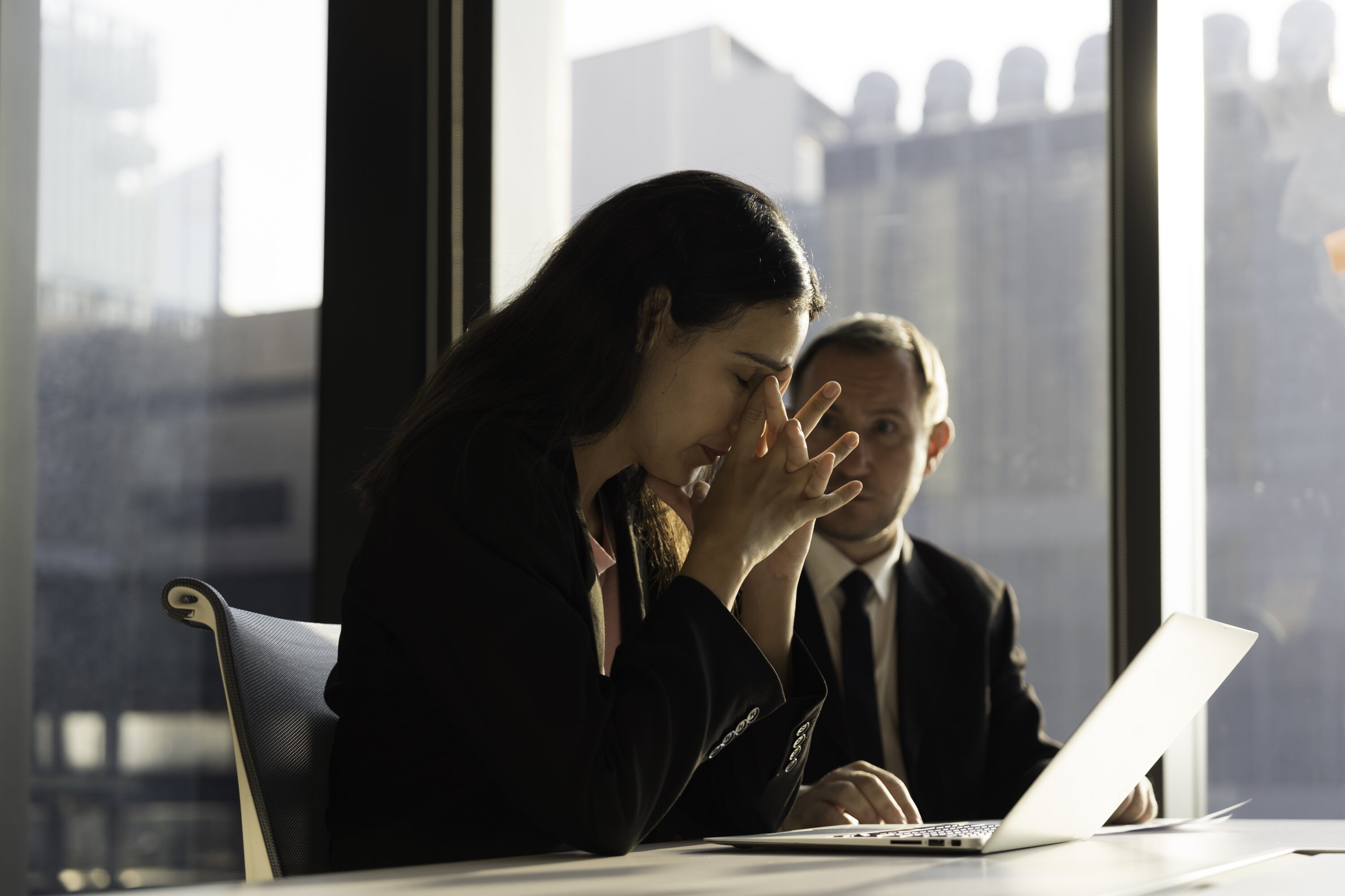 stressed,businessman,and,woman,discussing,business,deal,together,with,document