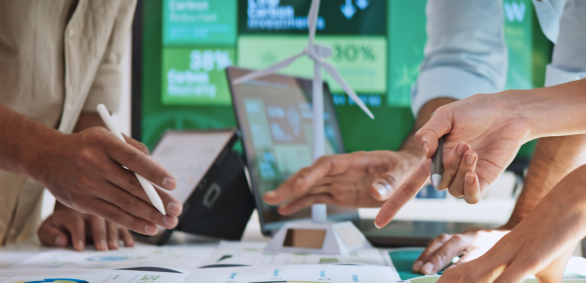 Hands pointing at eco-friendly charts and data